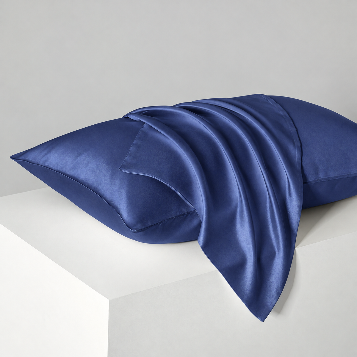 Navy satin pillowcases — diagonal studio view